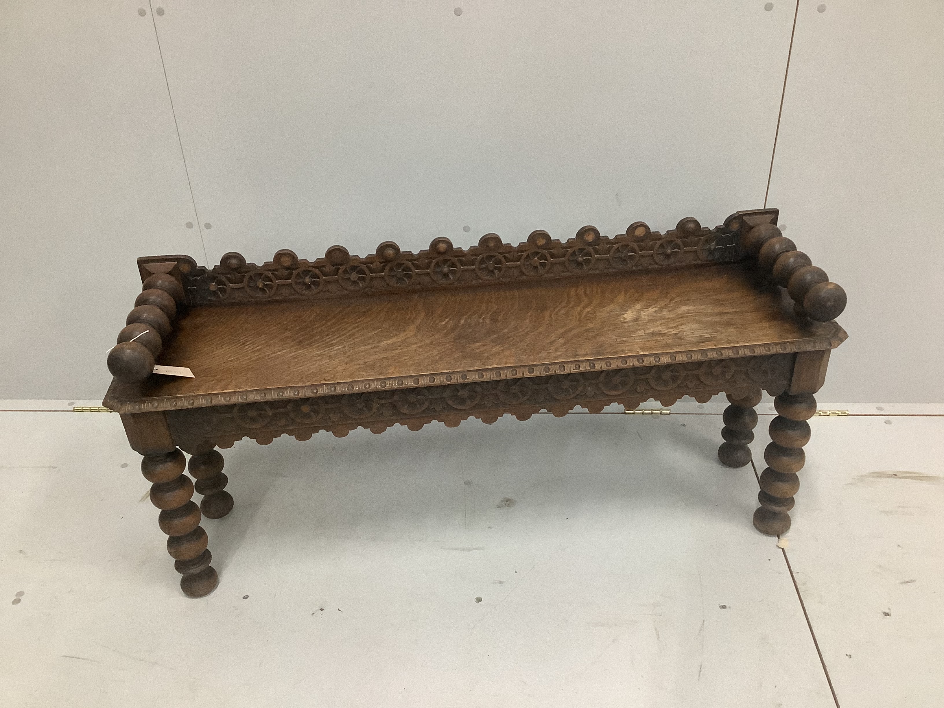 A late Victorian carved oak window seat, width 123cm